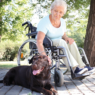 Glückliche Seniorin zusammen mit Hund